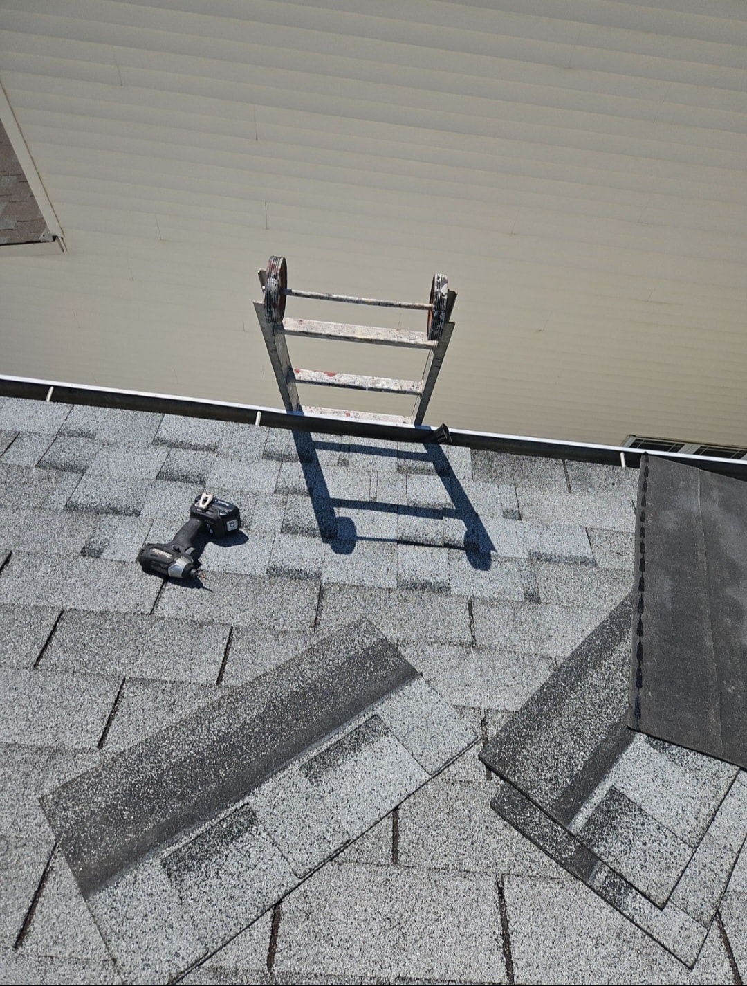 Emergency roof repair — ladder and drill on shingle roof during same-day repair
