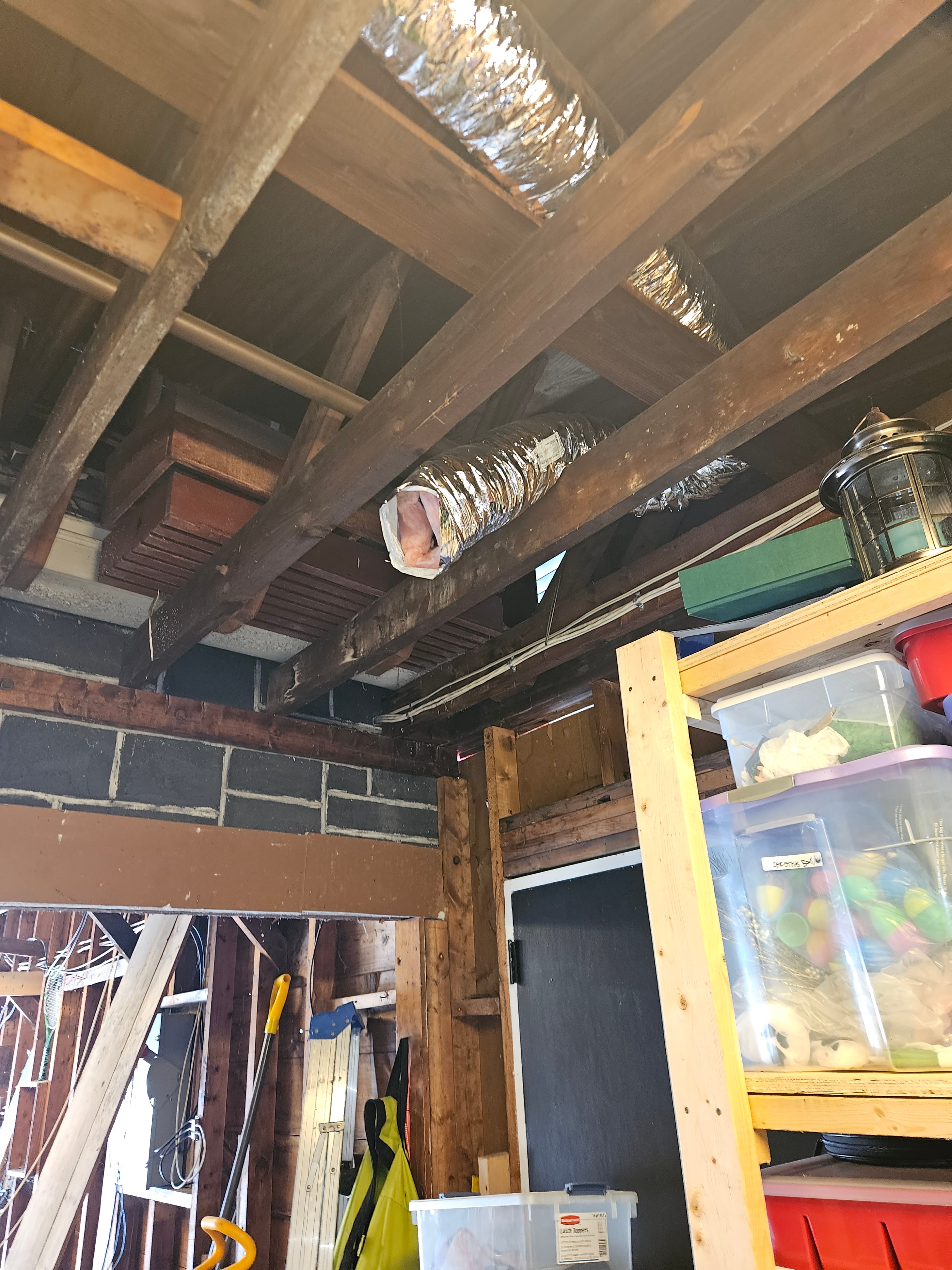 Flexible ductwork rerouted through attic crawl space framing during bathroom vent project